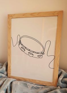 a drawing of a drum in a wooden frame on a bed with a blue blanket