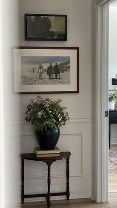 a vase with flowers sitting on top of a table in front of an open door