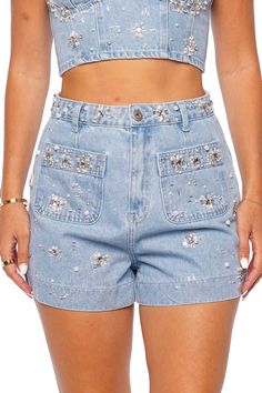 These high waisted denim shorts feature hand beaded rhinestone and pearl detailing throughout. Zip fly, button fastening Front patch pockets 100% cotton Dry clean only Embellished High-waist Denim Bottoms, Rhinestone Denim Jean Shorts, Embellished Denim Jean Shorts, Trendy Embellished Denim Jean Shorts, Denim Shorts With Rhinestones, Embellished Jean Shorts For Summer, Summer Embellished Cotton Jeans, Trendy Embellished Jean Shorts, High Waisted Denim Shorts