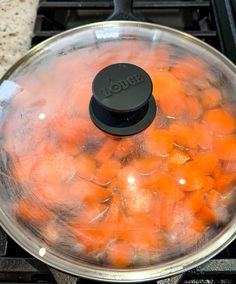 carrots are being cooked in a pot on the stove top with water and oil