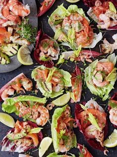 many different types of food are arranged on the counter top, including lettuce and shrimp