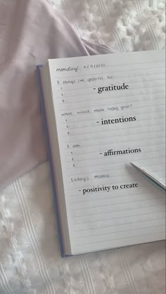 an open notebook with writing on it and a pen resting on the book's page