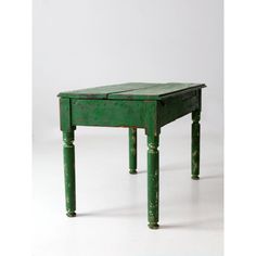 an old green table with two legs and a drawer on the top, sitting against a white background