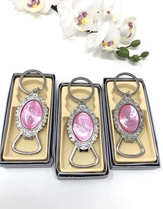 three pink and silver bottle openers sitting next to each other