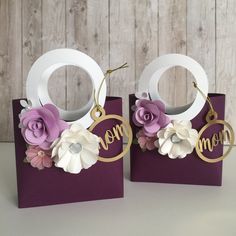 two purple and white paper bags with flowers on them, one has the word mom hanging from it