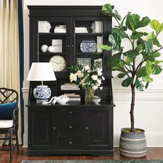 a living room with a black bookcase and white flowers