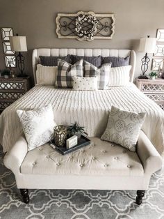 a white bed sitting in a bedroom on top of a gray and white carpeted floor