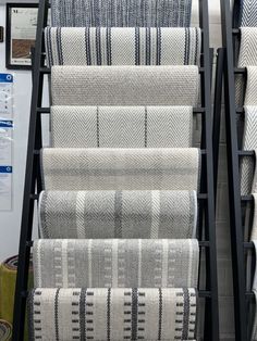 A set of mellow colored carpets on a carpet rack in our showroom Stair Runner Trends 2023, Modern Staircase Runner, Pinstripe Stair Runner, Dark Carpet On Stairs, Accent Carpet On Stairs, Beach House Stair Runner, Stanton Carpet Stair Runner, Carpet Trends 2023 Living Room, Textured Carpet On Stairs