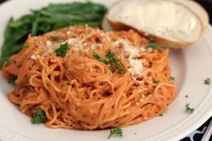 a white plate topped with spaghetti and bread