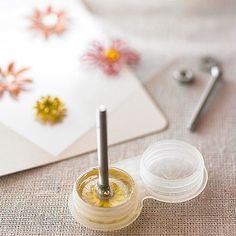 an open jar of nail polish sitting on top of a table next to some scissors