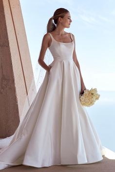 a woman in a white wedding dress holding a bouquet