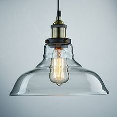 a clear glass light hanging from a ceiling fixture with an old fashioned bulb on it