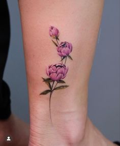 a pink flower tattoo on the ankle