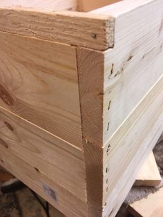 a wooden box sitting on top of a pile of wood