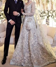 the newly married couple pose for a photo in their lavish wedding dress and tuxedo