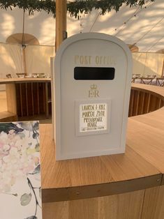 a white mailbox sitting on top of a wooden table next to a post office