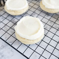 cookies with white frosting sitting on a cooling rack, ready to be made into desserts