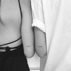 two people with small tattoos on their arms, one is holding the other's arm