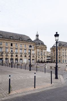 an empty square with benches and lamps in the middle