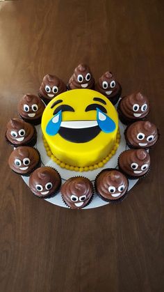 a yellow cake with chocolate cupcakes in the shape of an emoticive face