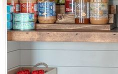 an open shelf filled with canned food and condiments on top of a kitchen counter