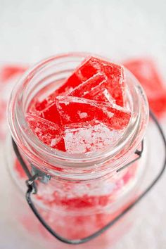 a glass jar filled with sugar cubes on top of a table