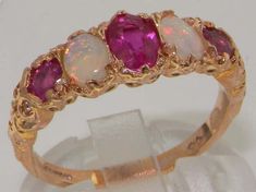 three stone ring set in yellow gold with pink and white opal stones on the band