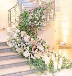 a bunch of flowers that are sitting on some kind of stairs with candles in front of them