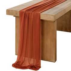 an orange scarf draped over a wooden bench