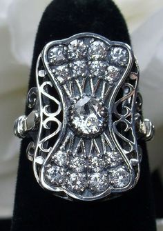 "Ring Description #134  This is an exquisite reproduction of an Art Deco ring. This filigree sterling silver ring is set with flawless faux white diamonds (approx.2.75ctw). There are 17 full cut cubic zirconias. The ring sits 22mm (7/8\") NS on the finger. The inside of the band is marked 925 for sterling. Notice the beautiful craftsmanship of the silver filigree setting and band. A ring gift box is included. Feel free to ask questions and thanks for looking at my listings. Suggest retail $139+ Gatsby Design, White Gold Engagement Rings Vintage, Rose Gold Engagement Ring Vintage, Stock Design, Moonstone Engagement, Unique Diamond Rings, Moonstone Engagement Ring, Engagement Ring White Gold, Curved Wedding Band