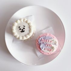 two decorated cookies sitting on top of a white plate