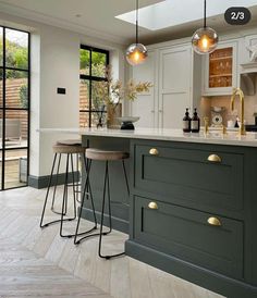 a kitchen with two stools next to an island in the middle of the room