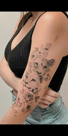 a woman's arm with flowers and a lion tattoo on the left side of her body