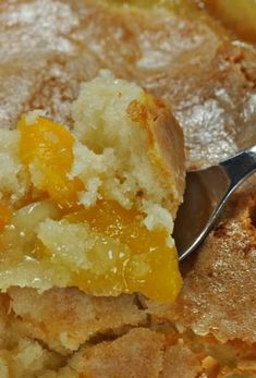 a close up of a piece of cake with a spoon in it and the words mom's magic peach cobbler