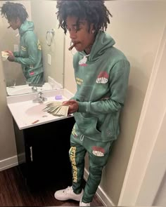 a young man standing in front of a bathroom mirror