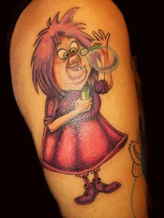 a cartoon character tattoo on the arm of a woman with a glass in her hand