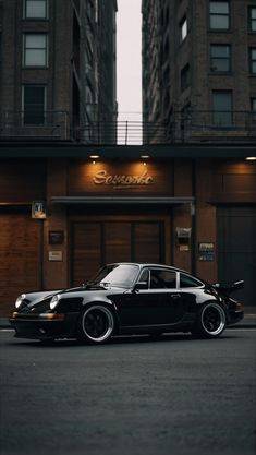 a black car parked in front of a tall building