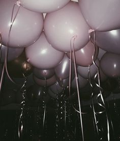 many pink and white balloons floating in the air