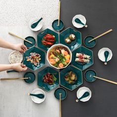 several people are sitting at a table with plates and bowls of food on it,