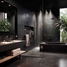 a large bathroom with black walls and tile flooring, along with a plant in the corner