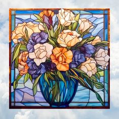 a blue vase filled with lots of flowers on top of a stained glass window sill