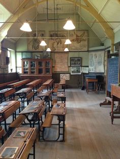 an old school room with wooden desks and benches