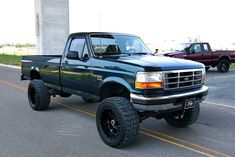 a blue pick up truck parked on the side of the road