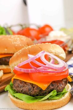 two hamburgers with onions, tomato and lettuce