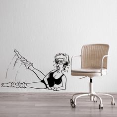 a drawing of a woman on the wall next to an office chair with a laptop