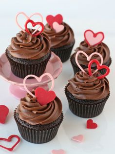 cupcakes with chocolate frosting and hearts on top