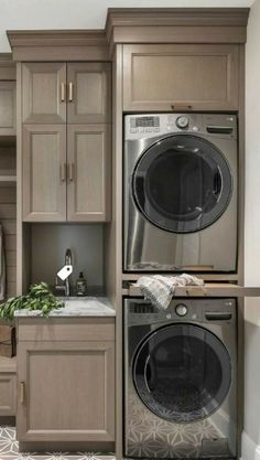 a washer and dryer in a room with wooden cupboards on the wall