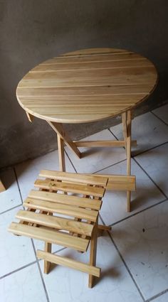 a wooden table and bench sitting on top of a tiled floor