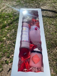 an open box with candles, soaps and other items in it on the grass