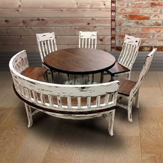 a round table with chairs around it in front of a brick wall and wooden floor